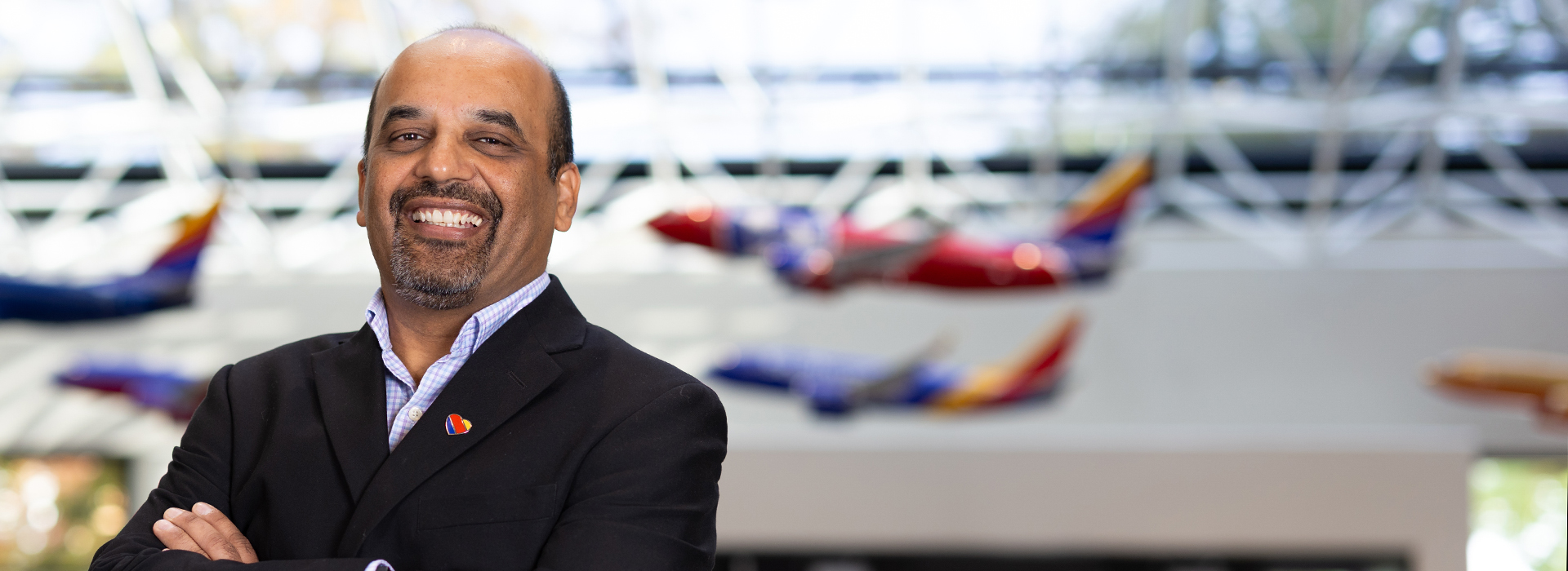 Hemal S. smiling with planes behind him