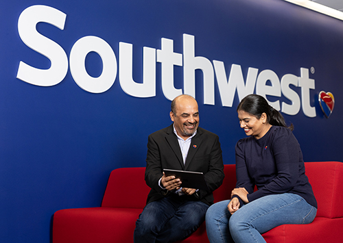 Two Southwest Employees working together on an electronic tablet. . 