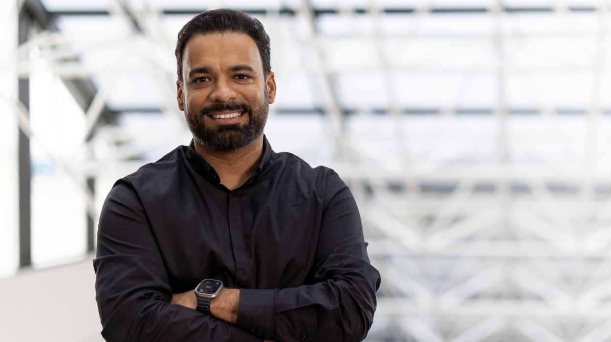 Bharat M. smiling with his arms crossed