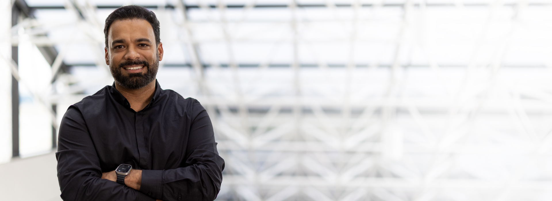 Bharat M smiling with crossed arms