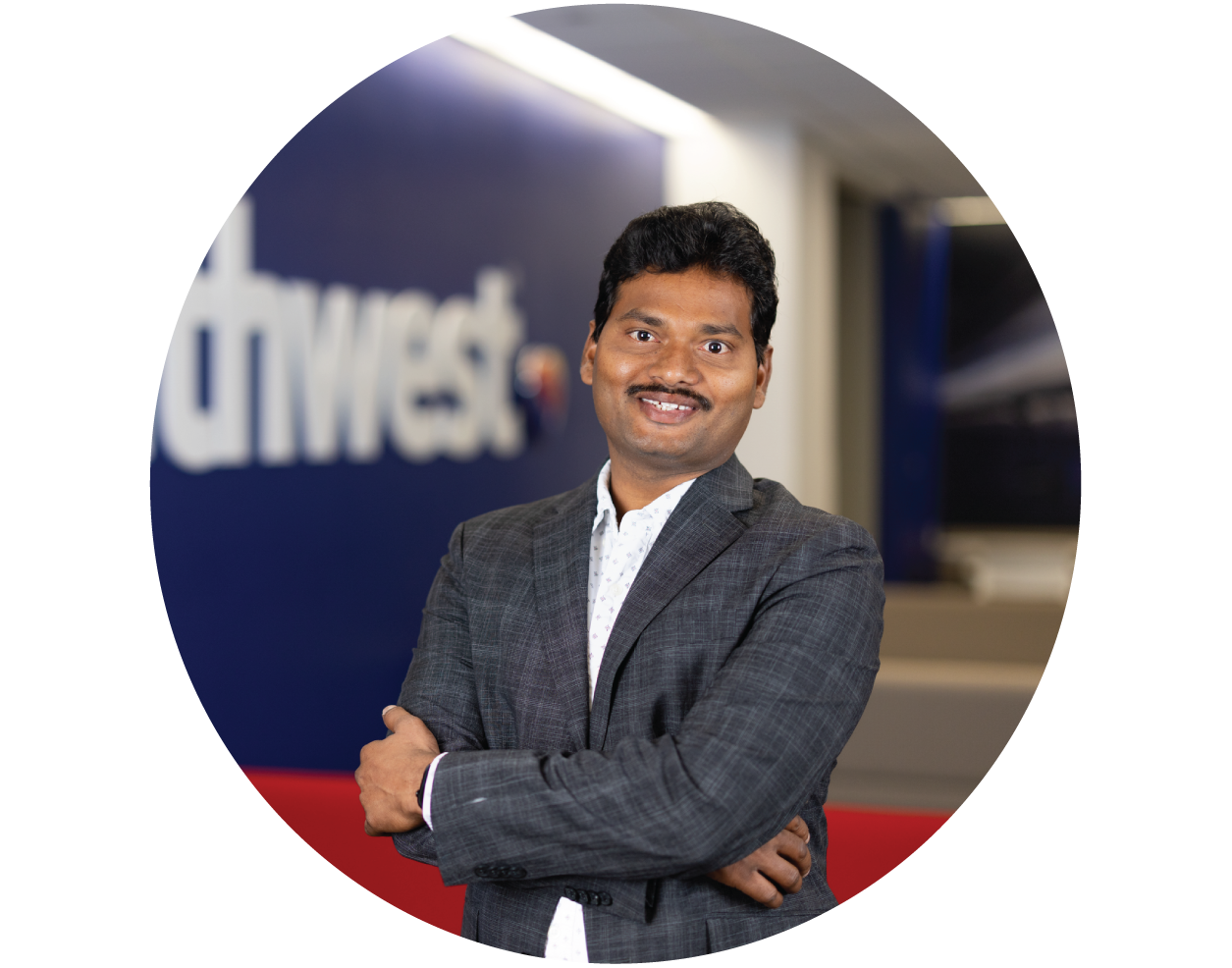 Employee smiling at the camera with arms crossed