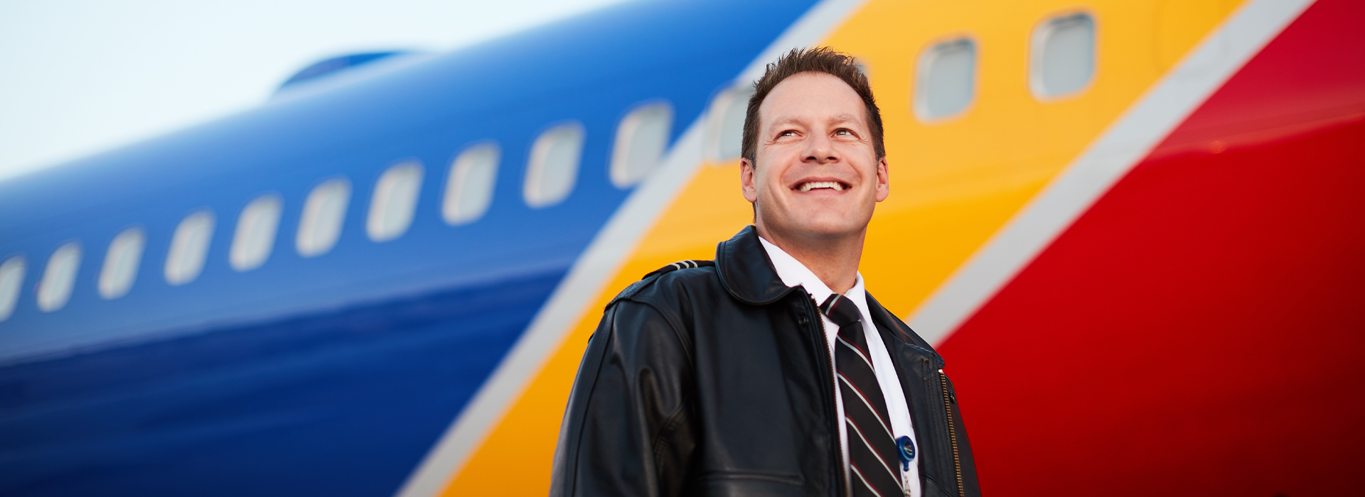 Southwest Airlines Pilot First Officer smiling in front of Southwest plane