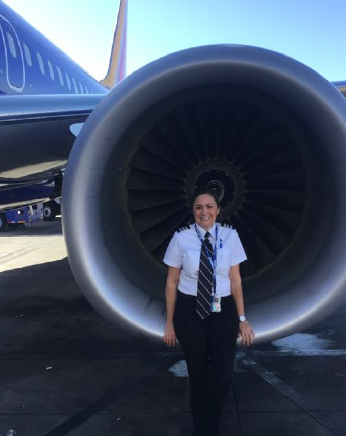 First Officer Marcella P. smiling in front of a Southwest 737