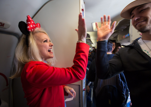 A flight attendant high-fiving a passenger