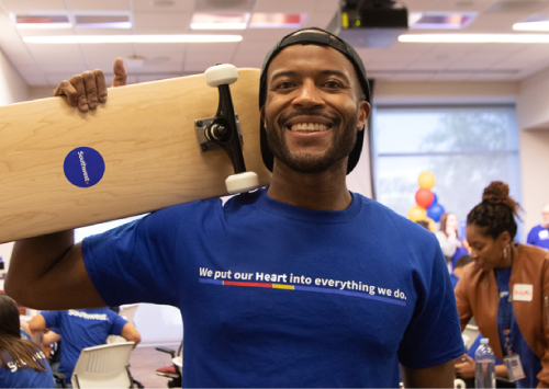 A Southwest employee holding a skateboard and smiling at the camera