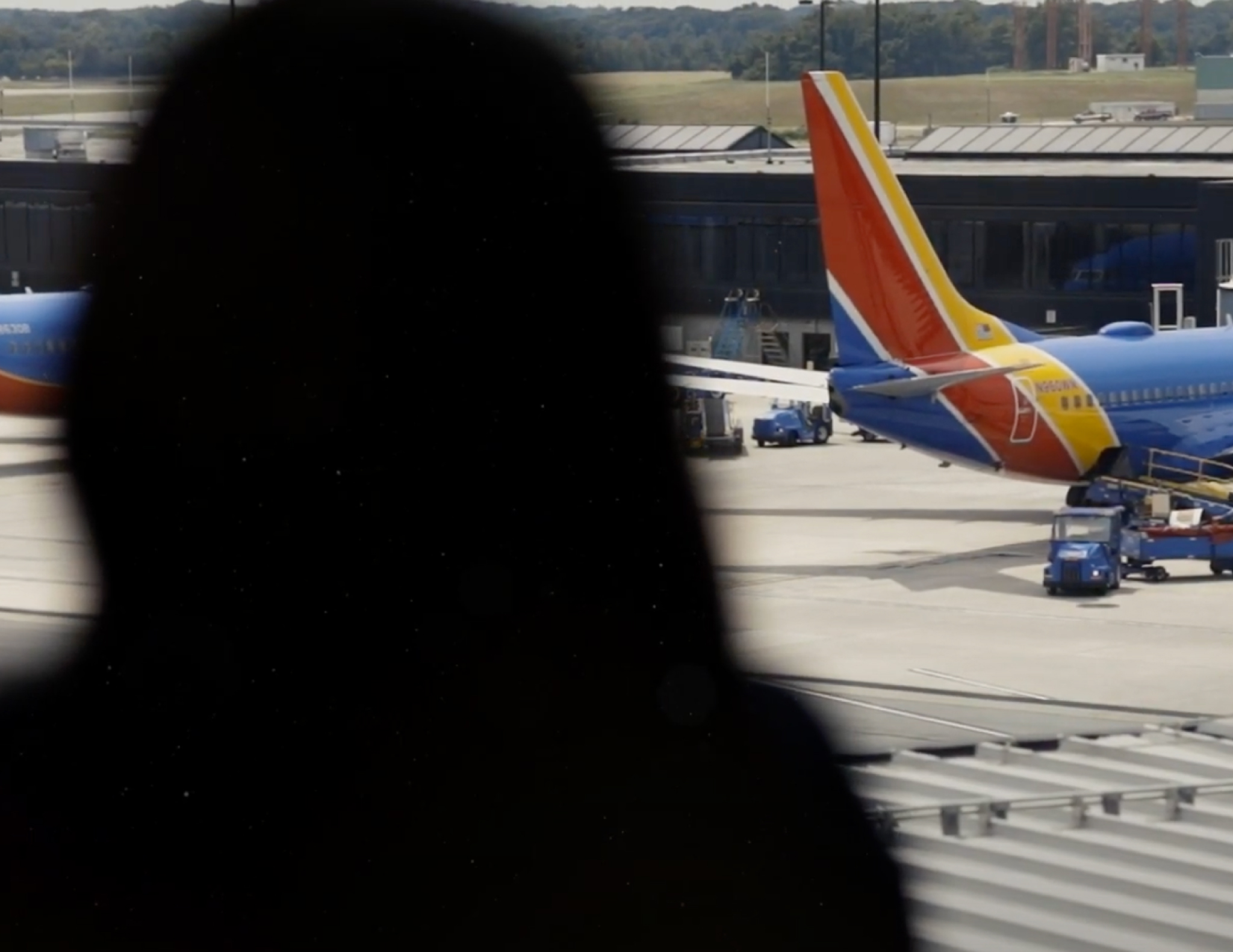 A silhouette of a woman looking at a Southwest plane