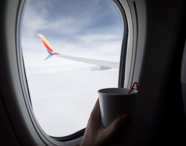 A view of a Southwest wing from the sky and a coffee cup being held to the window