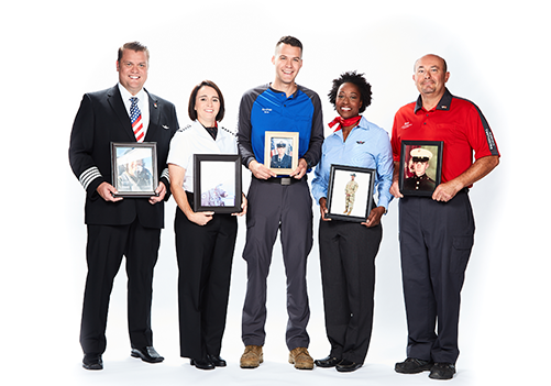 Group Southwest Employees who have served or are serving, holding portraits of them in their respective military uniforms.