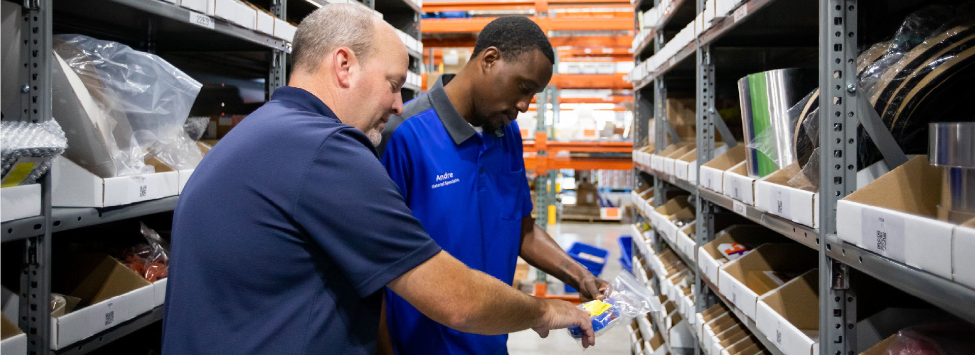 Two men looking at airplane parts in a warehouse