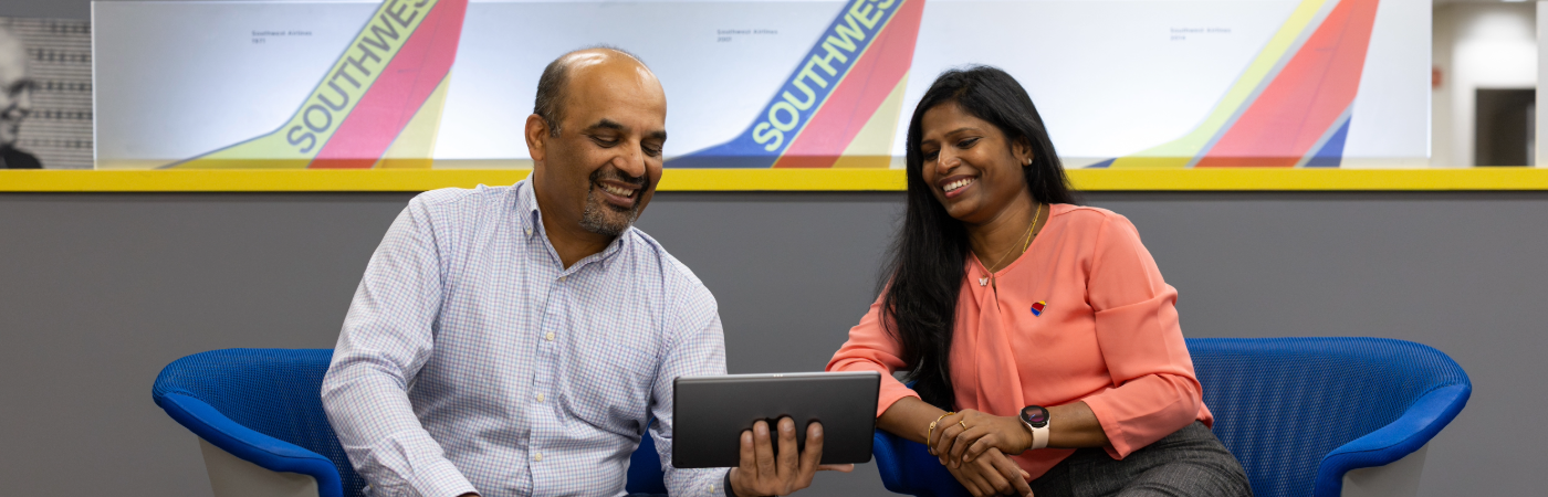 Two Southwest Employees smiling looking at a tablet.