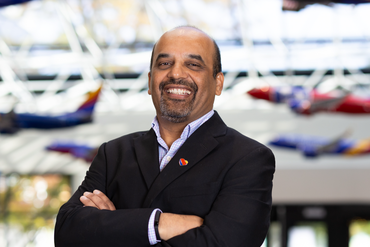 Southwest Employee, smiling, standing in front of Southwest model aircraft in a headshot style image