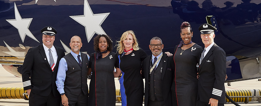 Southwest employees smiling in front of a Southwest plane