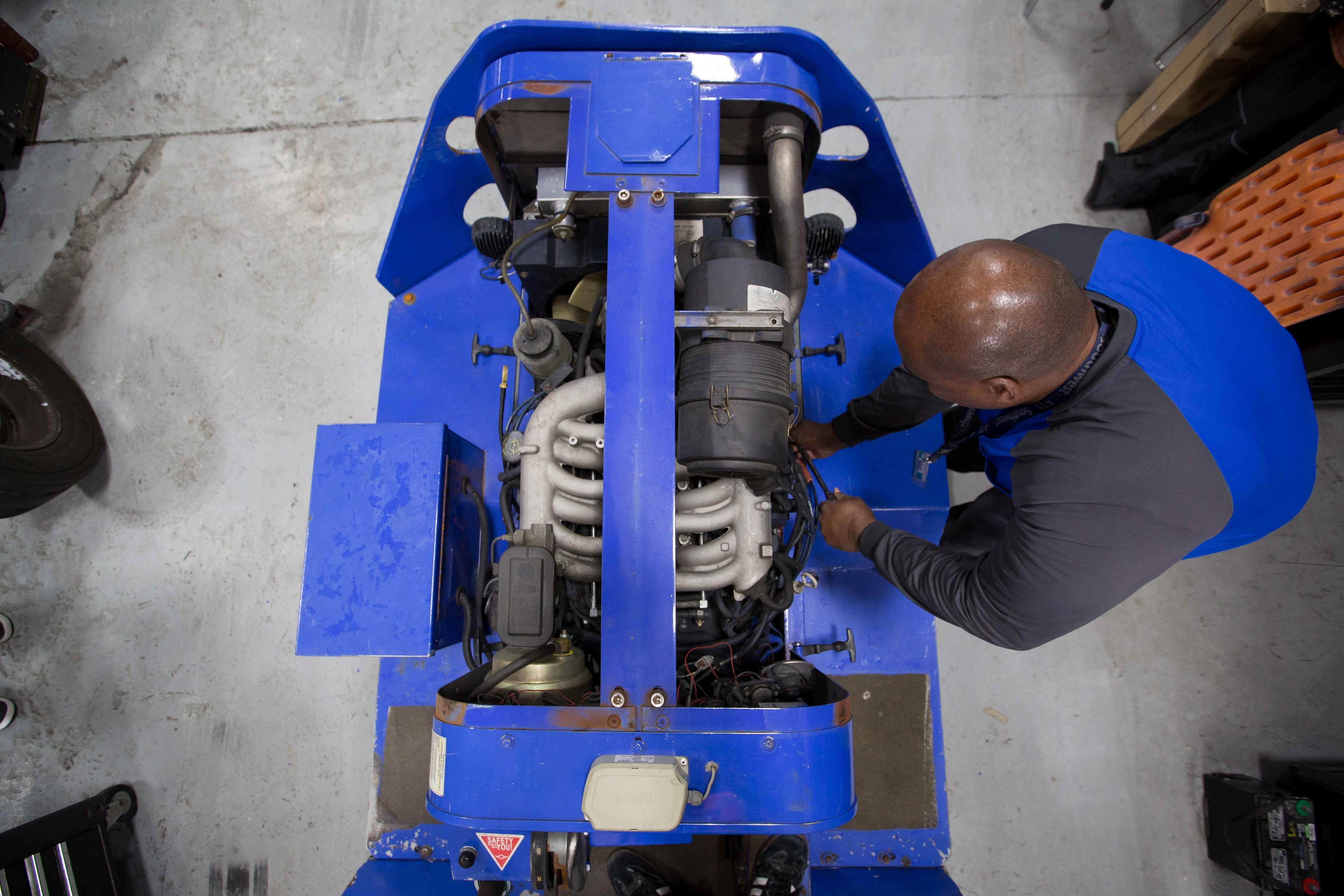 GSE Technician working on a car part with physical requirements listed. 