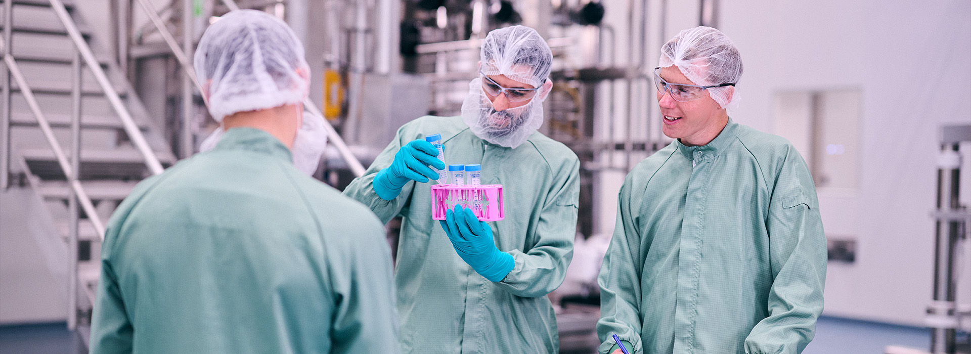3 colleagues in a group in a biomanufacturing plant