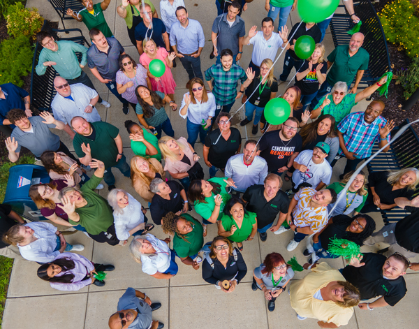 Group of Veritiv employees look overhead at the camera and releasing baloons.