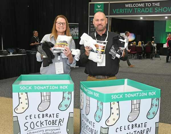 Two Veritiv employees holding bundles of socks for the Socktober donations.