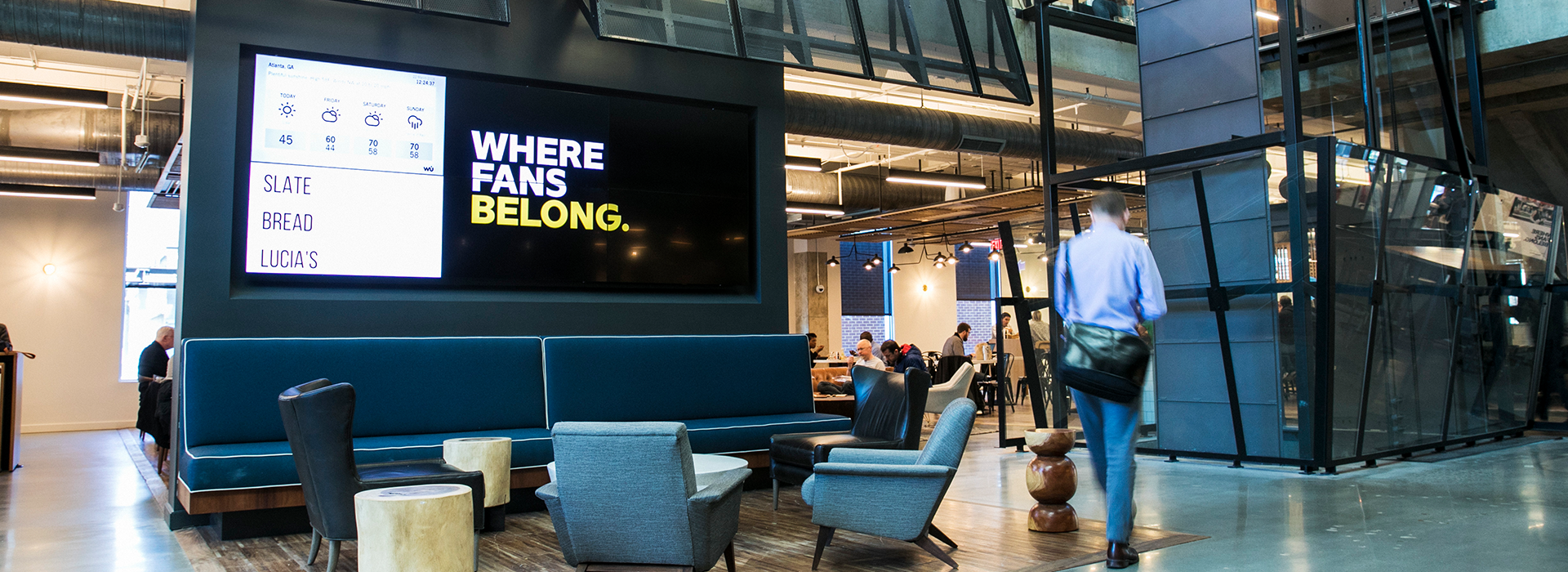 Three employees looking up at a giant globe at CNN World Headquarters