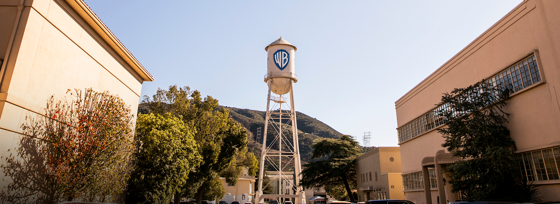 The Warner Bros. Studios water tower set against a blue sky and rolling green hills