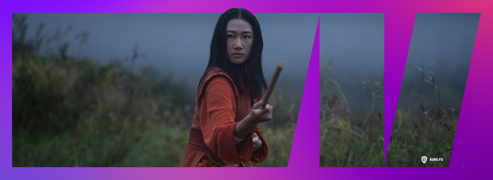 Nicky Shen from Kung Fu stands in a field holding her staff.